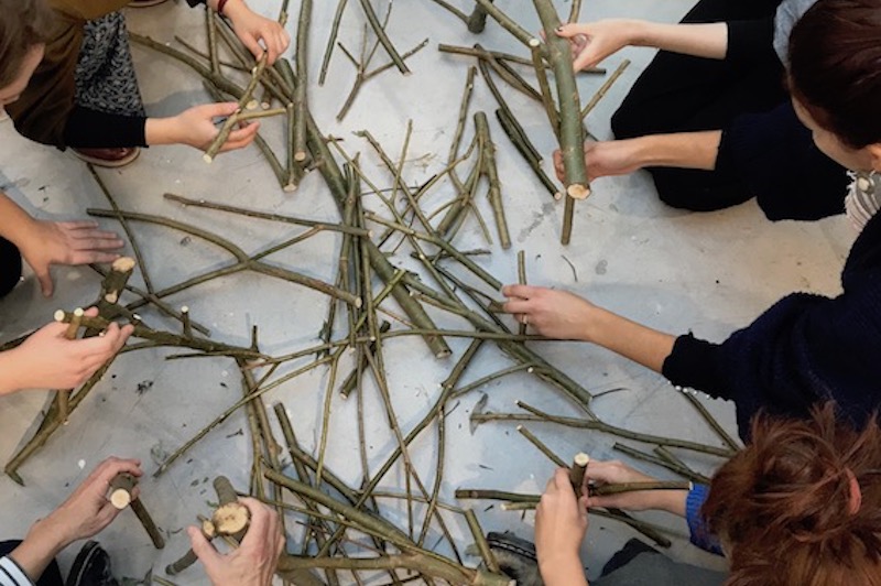 a group of people handling some sticks