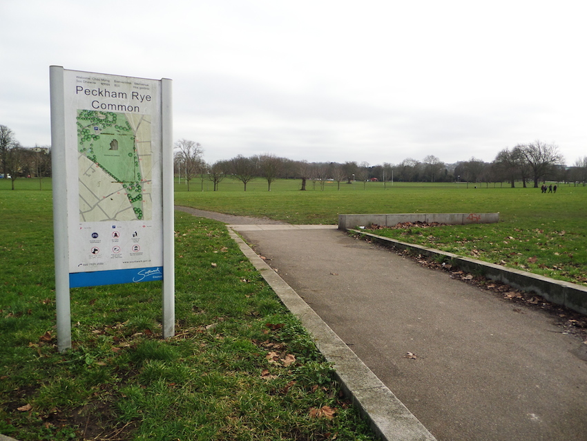 Large green open space with path and sign