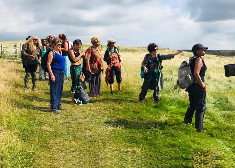 A group of black, brown and women of colour in a rural landscape